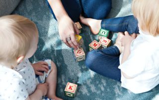 Two children and an adult playing with blocks