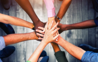 Close up view of young business people putting their hands together. Stack of hands. Unity and teamwork concept.